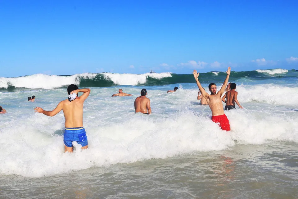To cool off from the 30 degree heat many fans run into the water for a swim before the match begins